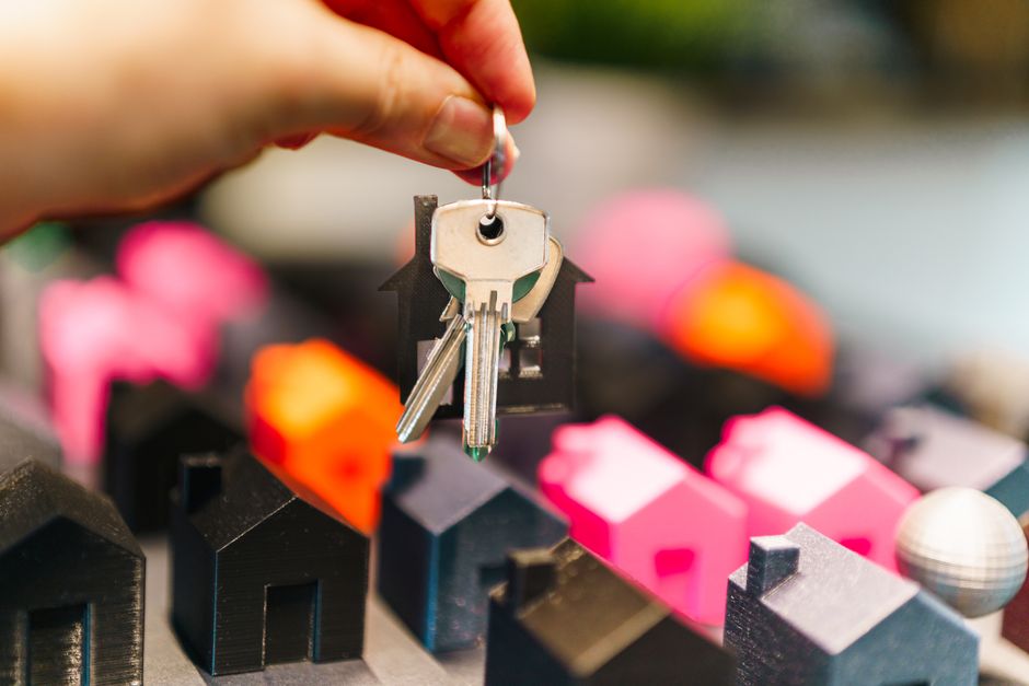 馬來西亞 Freehold Leasehold — Colorful miniature houses and a hand holding keys representi