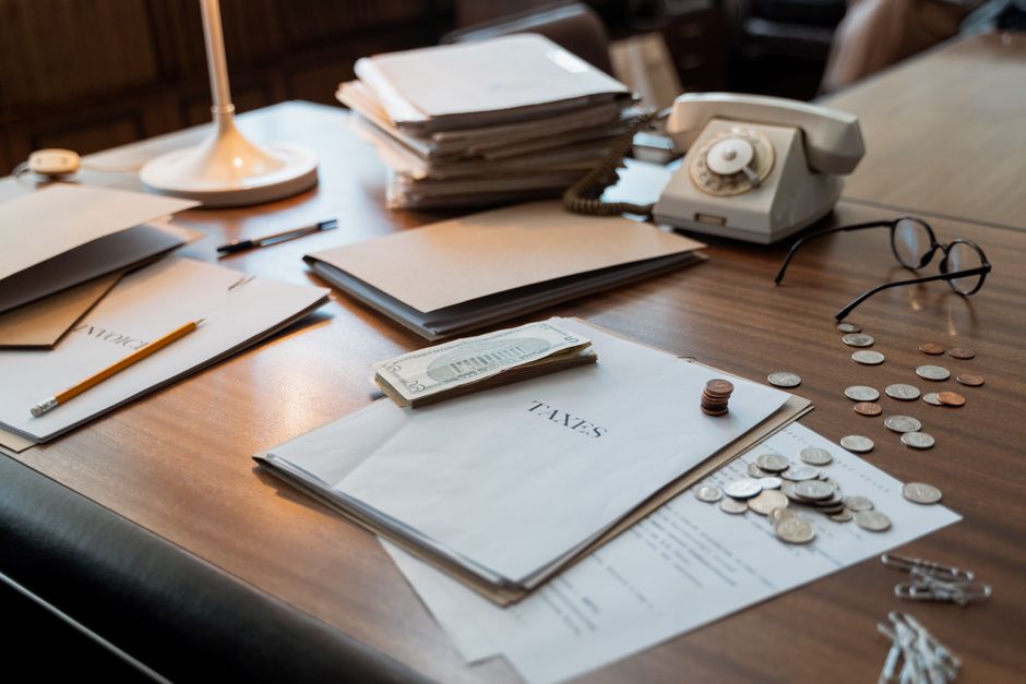 馬來西亞 稅務 居民 — Close-up of an office desk with tax documents, coins, glasse