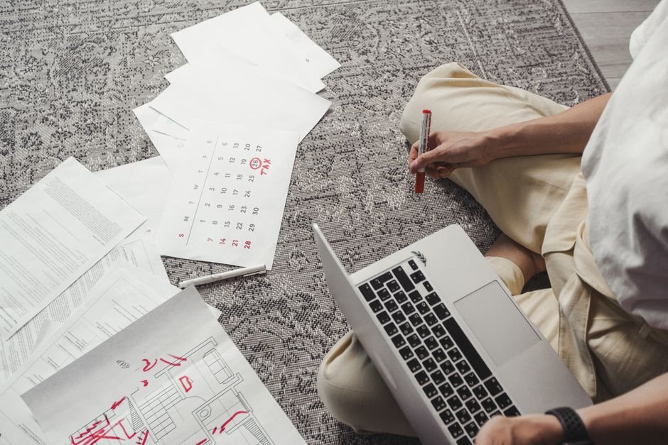 MM2H 申請 流程 — Young man working on plans with laptop and calendar, organiz
